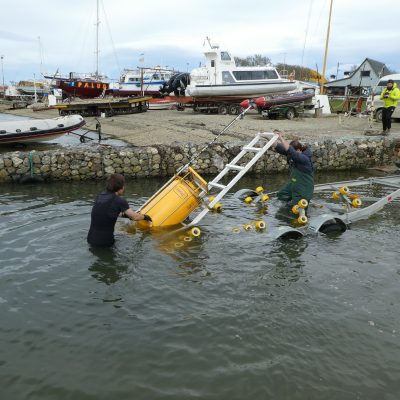 The buoy is in the water: Jacobo Martin and Ariel Giamportone, both from CADIC, deploy the buoy off the trailer and into the water. 